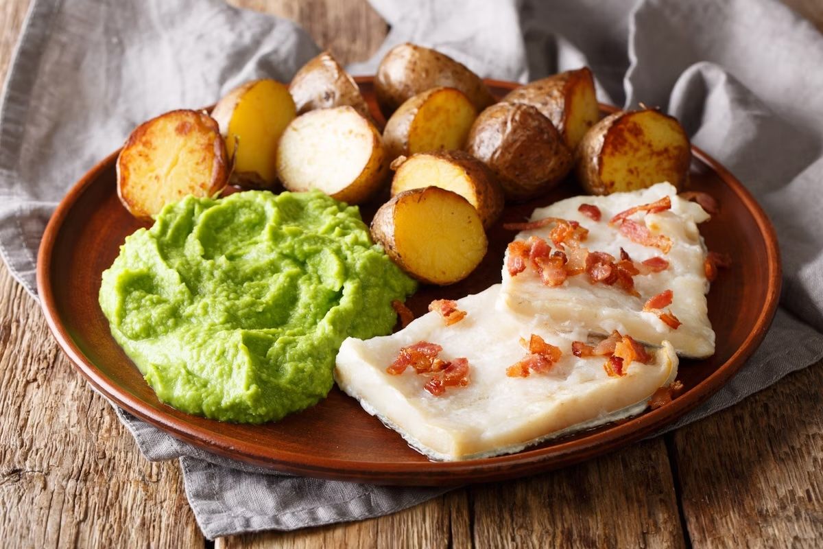 Lutefisk tradizionale, servito con purea di piselli, patate e pancetta su un piatto. ALLEKO/Getty Images