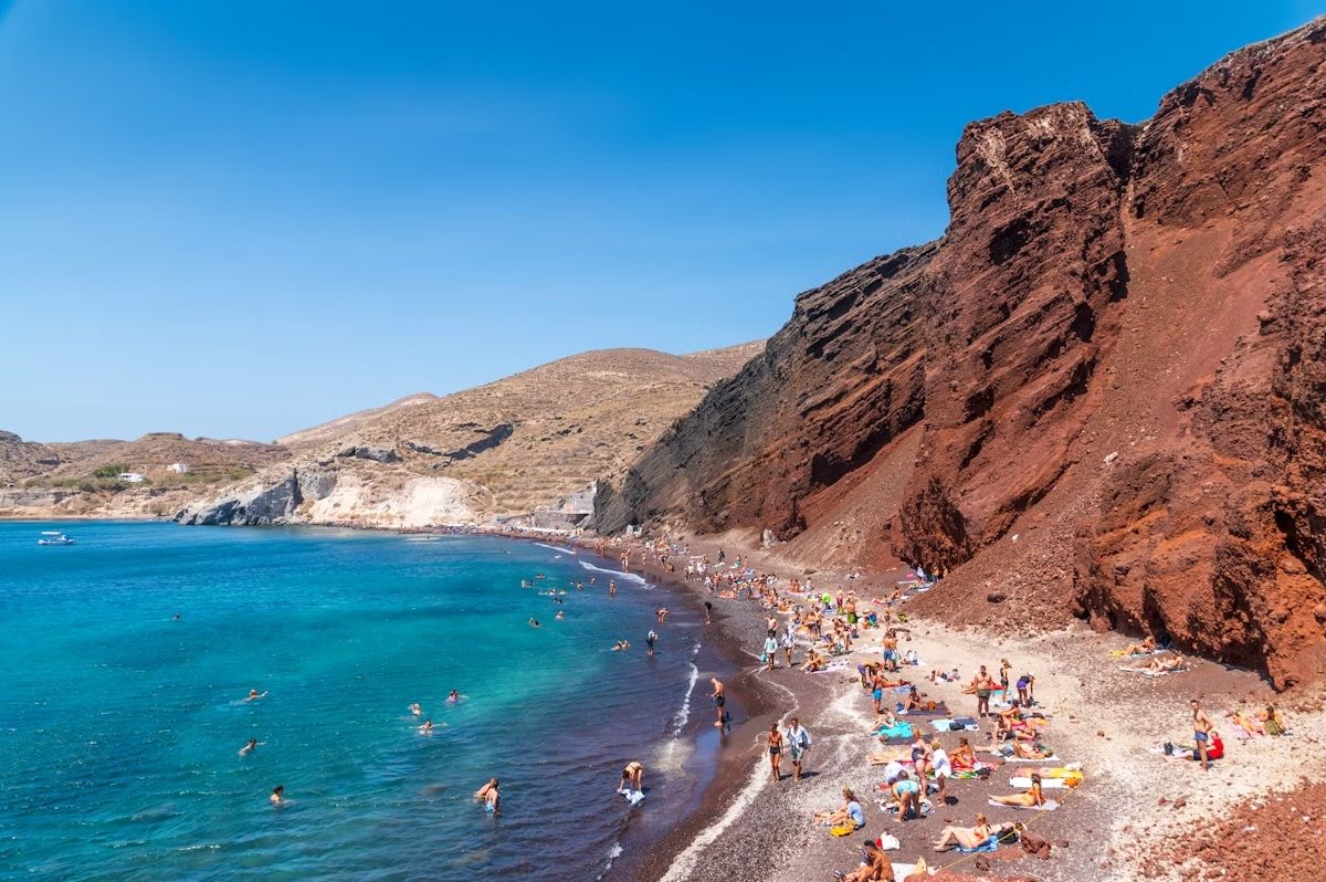 La spiaggia di Kokkini, color ruggine, è uno dei tratti di sabbia più popolari di Santorini. George Pachantouris / Getty Images