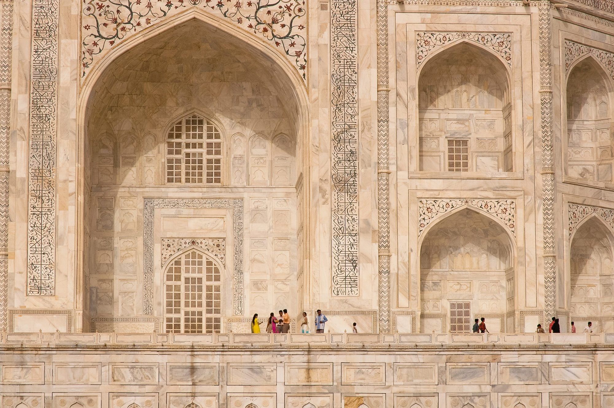 Persone in abiti colorati davanti all'imponente Taj Mahal, Agra, India ©Angelo DeSantis/Getty Images
