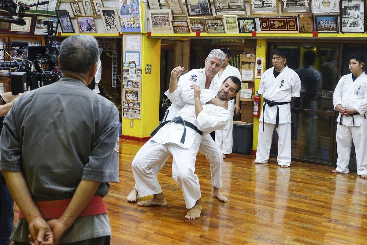 Bourdain alle prese con il tegumi, lotta tradizionale di Okinawa. © CNN