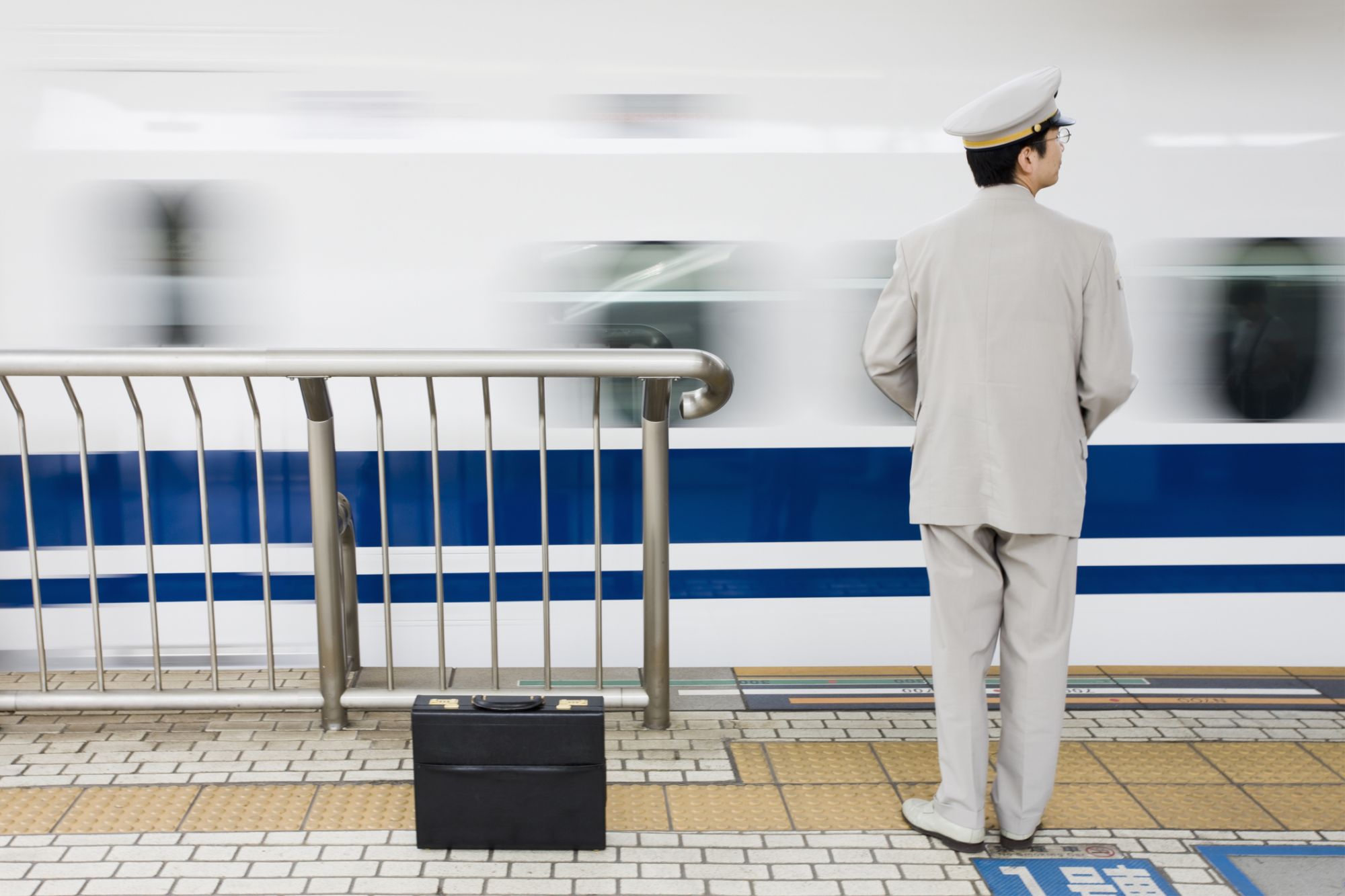 Uomo davanti al treno in una stazione in Giappone