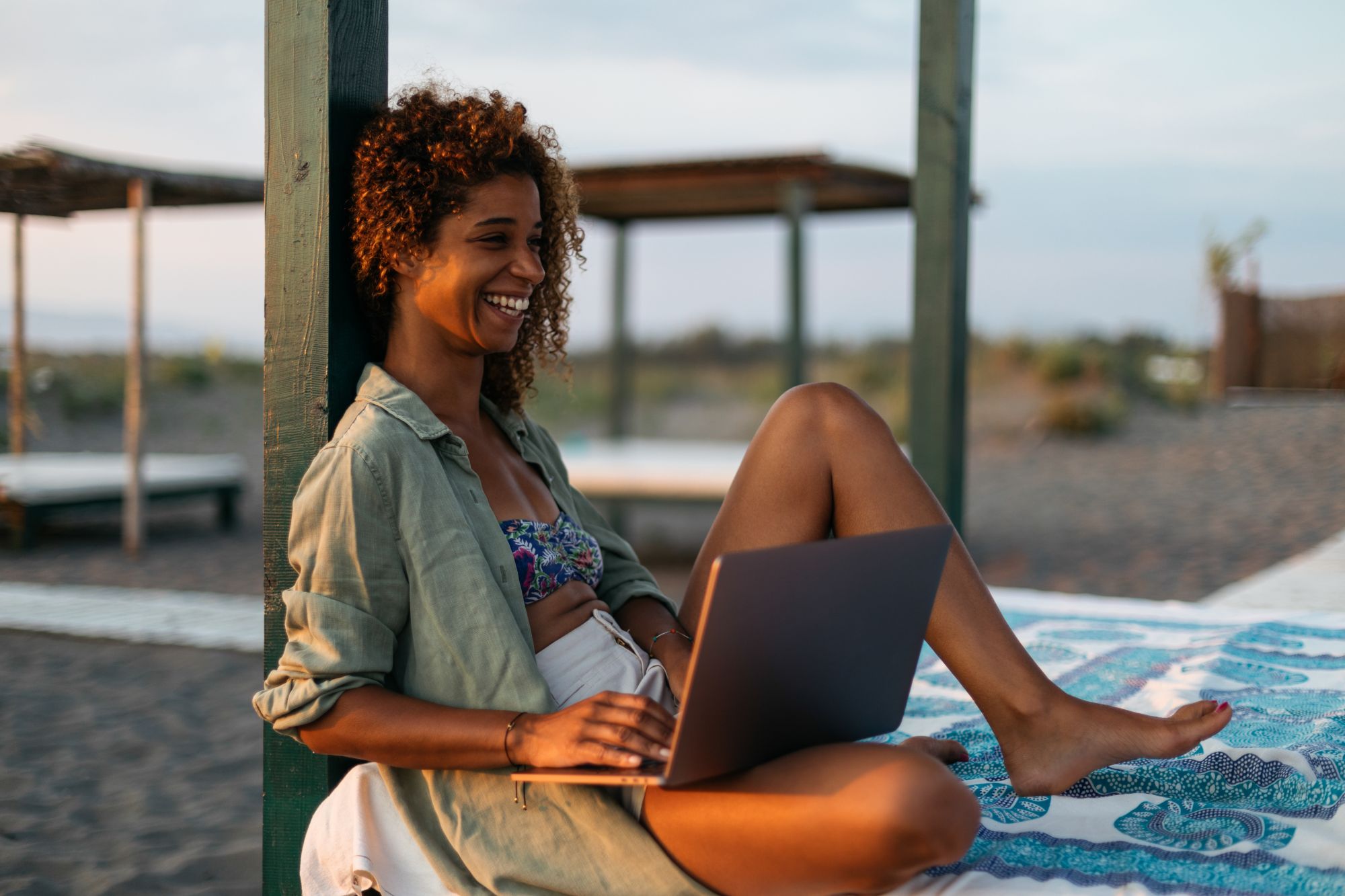 Ragazza che lavora al pc sulla spiaggia