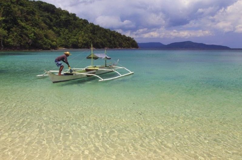 Barca nell'acqua cristallina della Turtle Bay in Palawan, Filippine. Foto di Michele Falzone/Photolibrary/Getty Images
