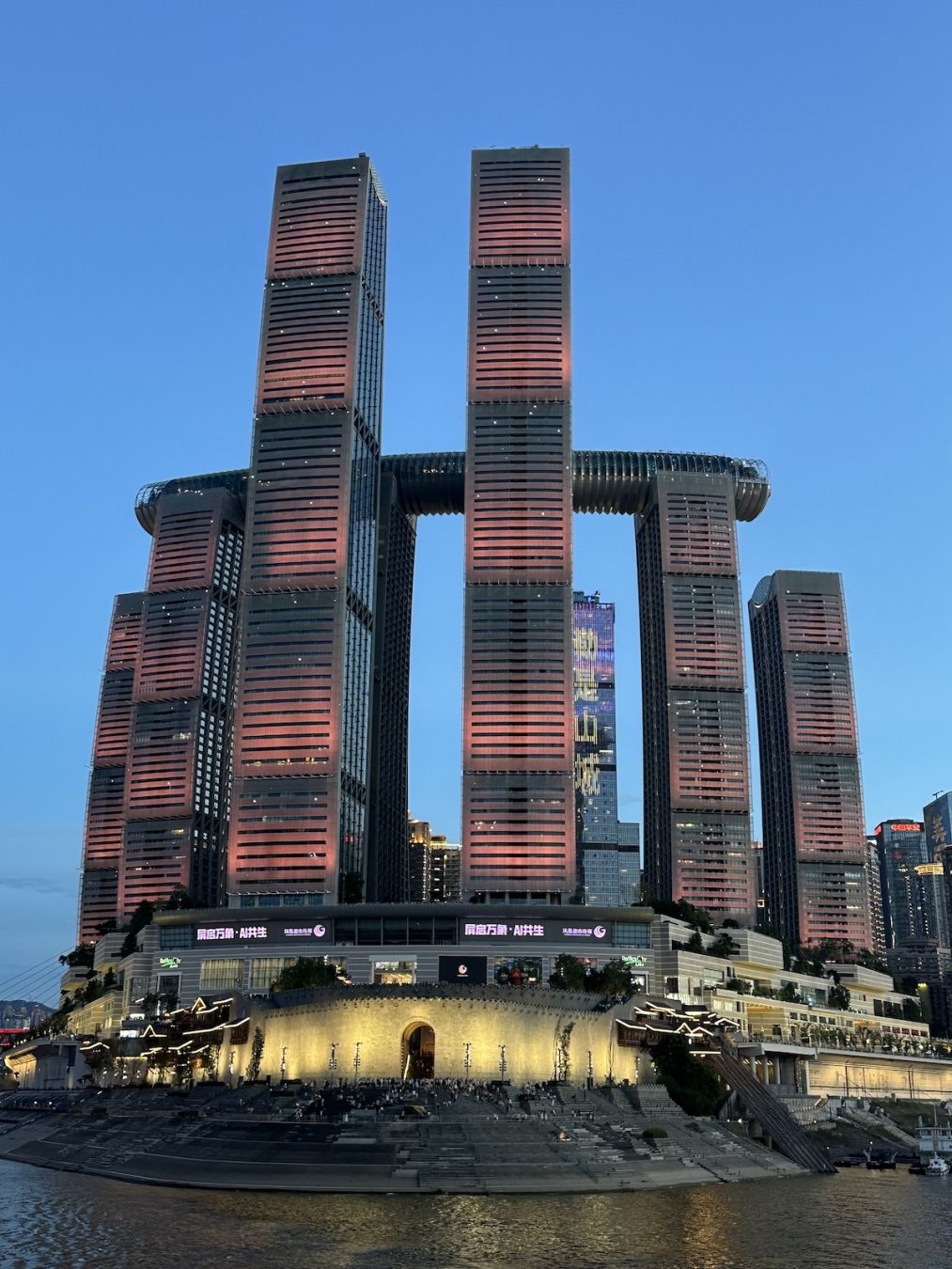 Raffles City Chongqing, il complesso di grattacieli illuminati di rosso e oro che si affaccia sul fiume; © Angelo Pittro