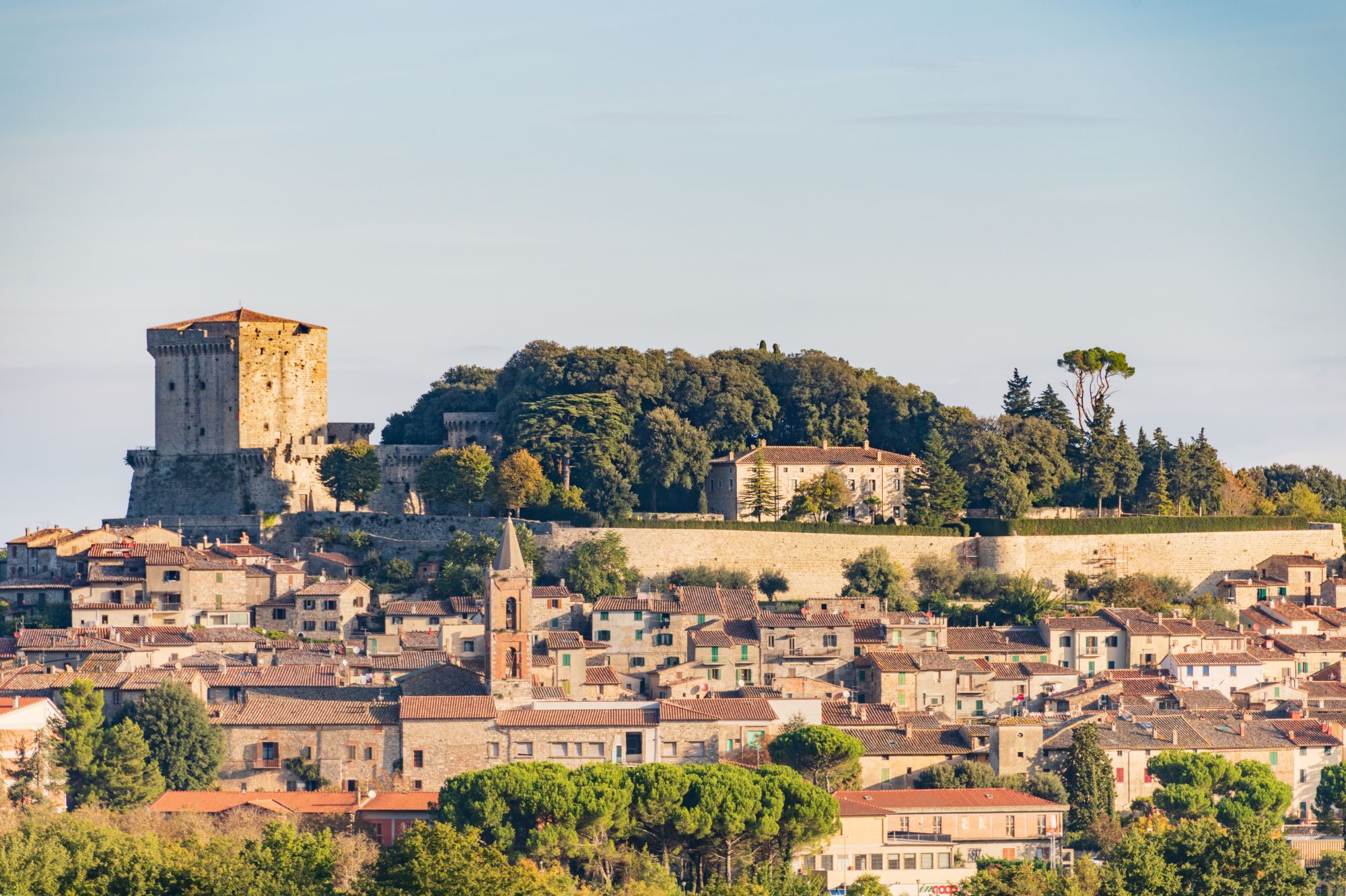 borgo medievale toscano, tetti e profili di case, cielo azzurro