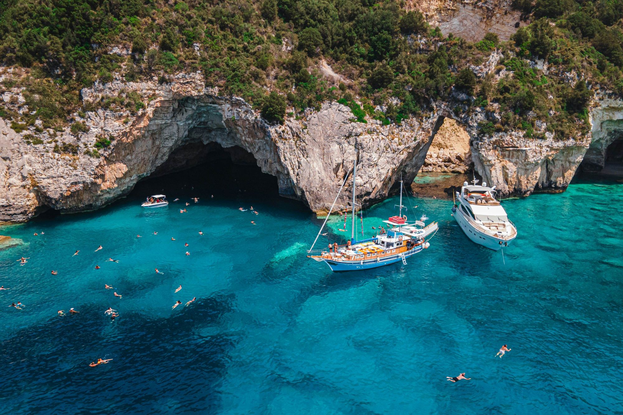 Barche a vela ormeggiate davanti alle Grotte Blu di Paxos: l’acqua cristallina garantisce nuotate da sogno. © Vladimir Borovic/Shutterstock