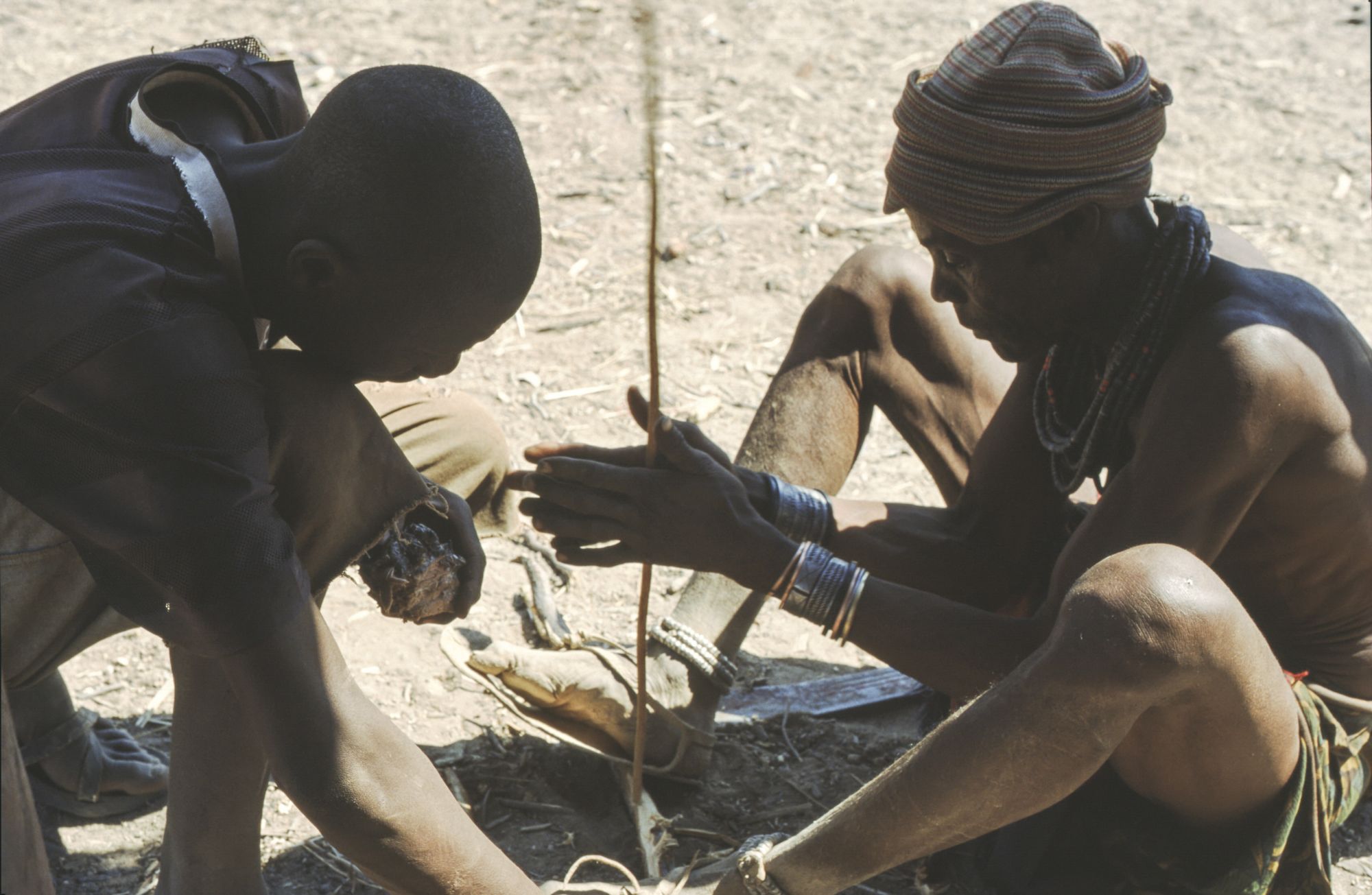 Due uomini di rtnia Hinba con un trapano da fuoco, in Namibia © Antonio Ancora