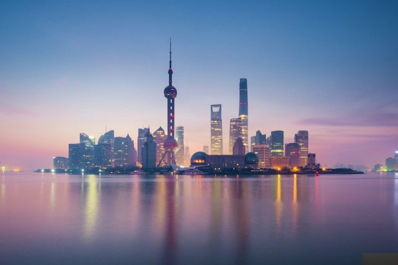 Leggeri strati di nebbia si adagiano al tramonto sull'iconico skyline di Shànghǎi. © tonnaja.com / Getty Images