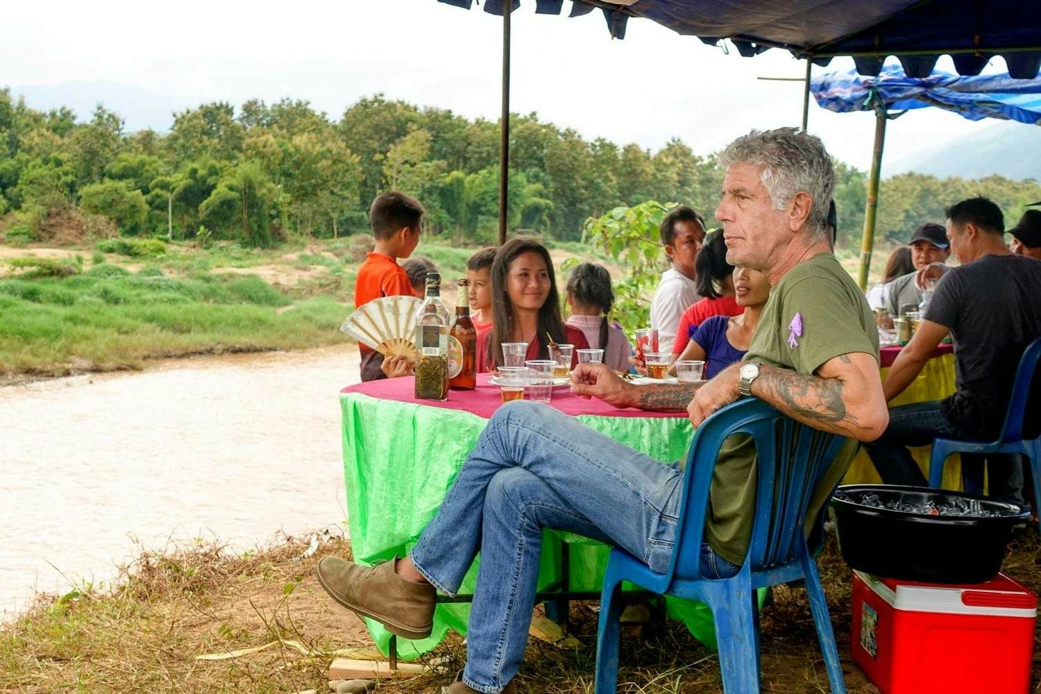 Bourdain si gode il cibo laotiano sulla riva di un fiume. © CNN