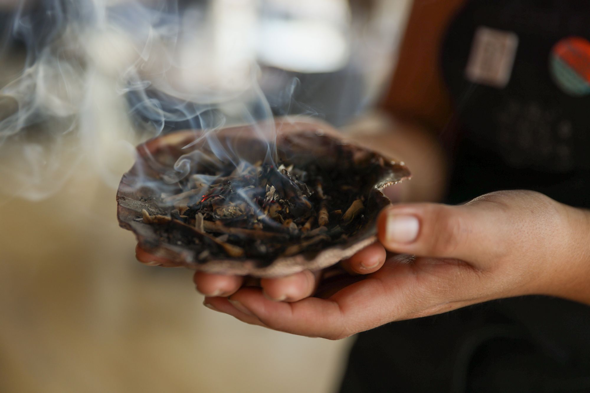 Prima dell’apertura del ristorante, un dipendente brucia la salvia in una conchiglia © Jaida Grey Eagle / Lonely Planet