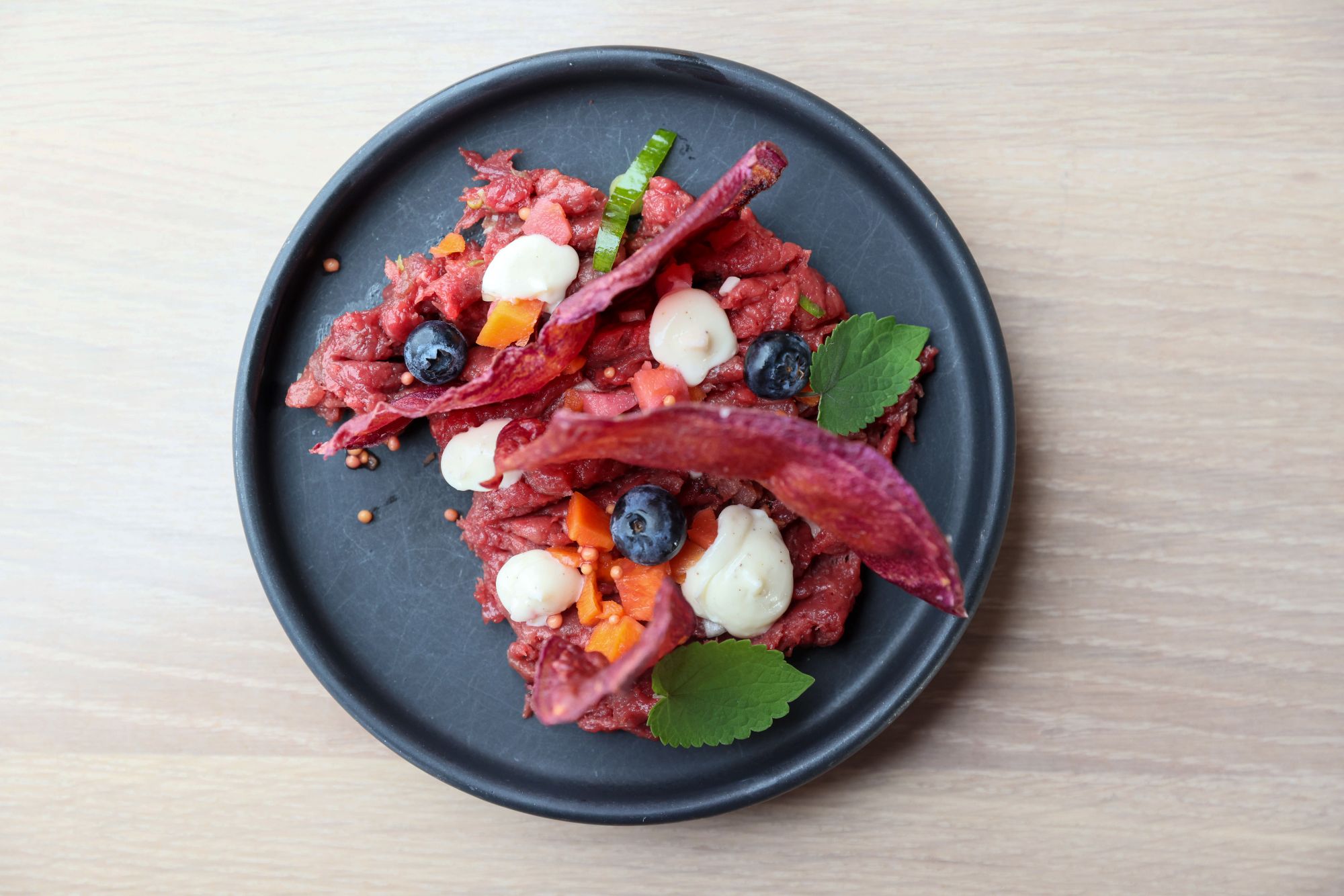 Cervo Wačhoničha: tartare di cervo, uovo di anatra al sommacco con salsa aioli, porro, patata dolce viola, carote sott’aceto © Jaida Grey Eagle / Lone